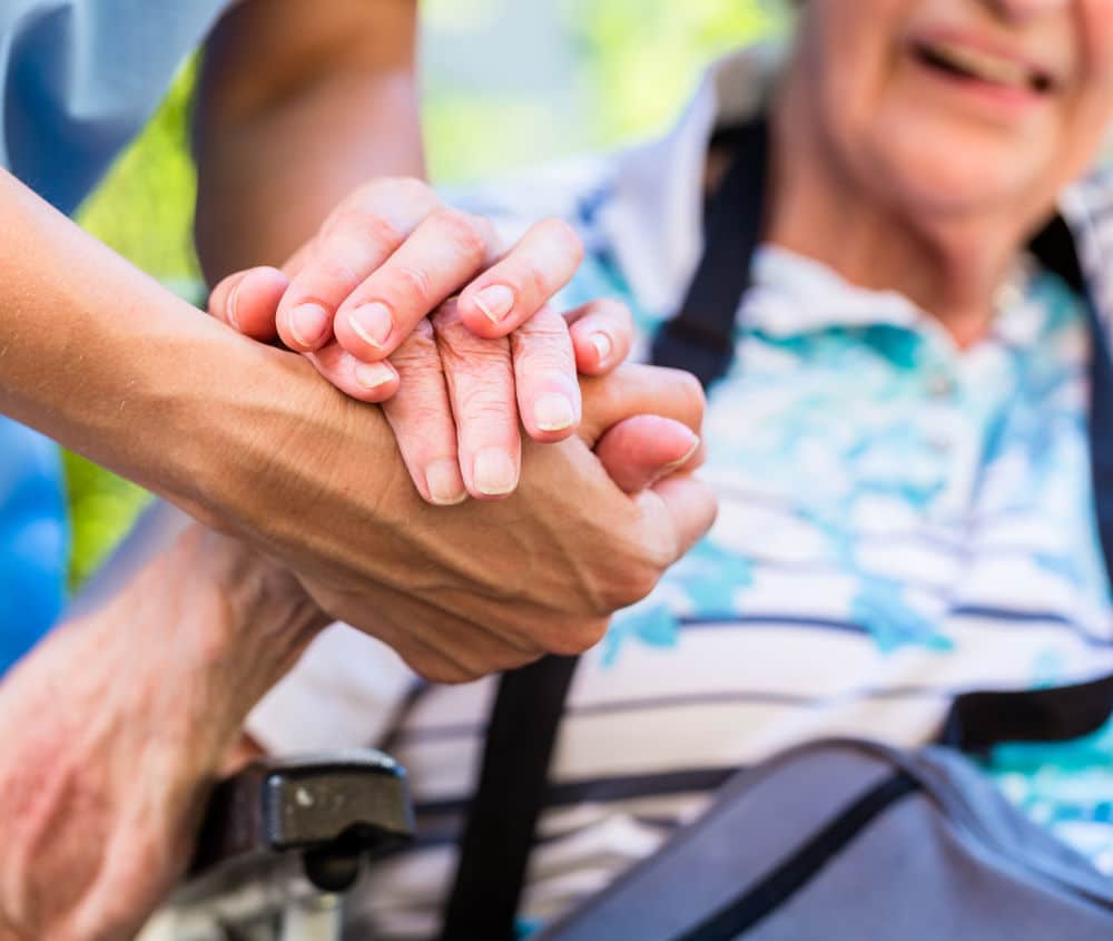 Nurse consoling senior woman holding her hand